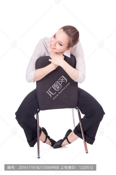 年輕的長頭發(fā)女人坐在黑色的椅子上