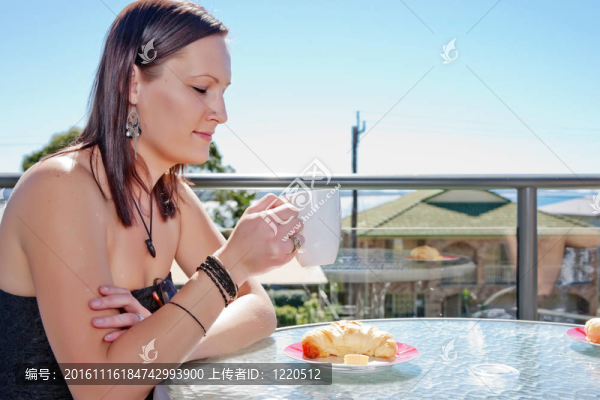 年輕婦女在咖啡館吃早餐