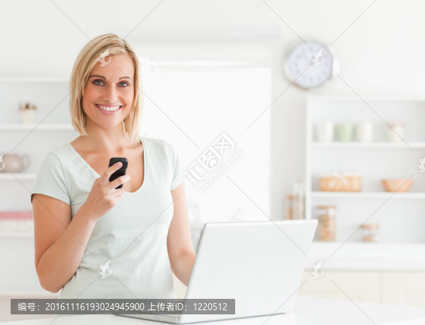 可愛(ài)的女人與移動(dòng)和筆記本電腦看相機(jī)