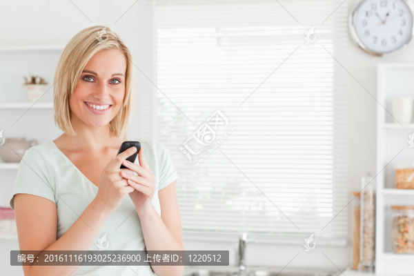 迷人的女人用手機看進(jìn)相機