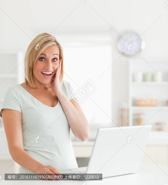 驚訝的金發(fā)女人拿著筆記本看著相機