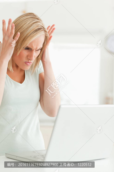 心煩意亂的女人看著她的筆記本電腦不知該怎么辦