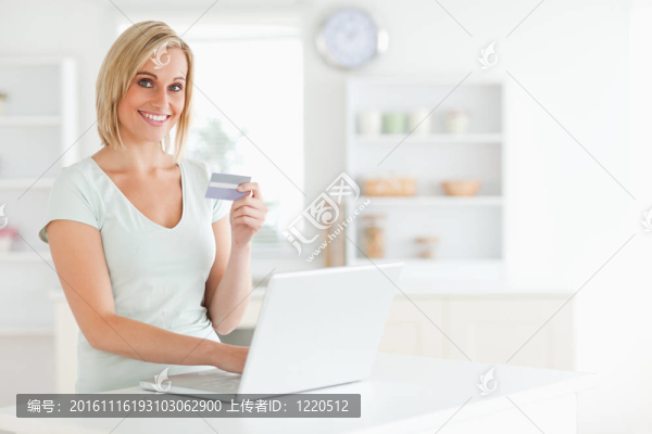 用信用卡和筆記本看電視的女人