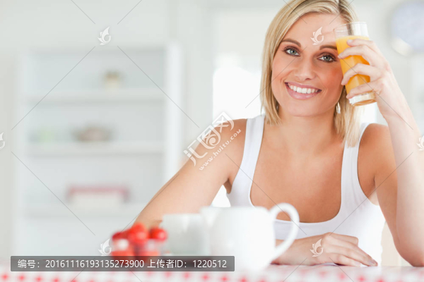 橙汁對她的額頭的女人抱著玻璃