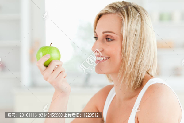 年輕女子看著綠色的一個蘋果