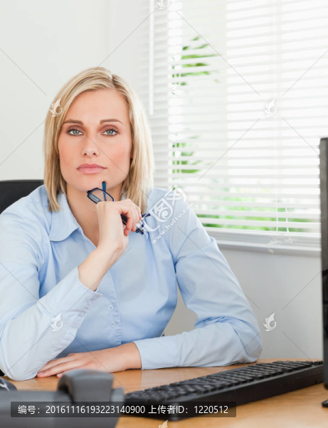 她書桌后面的嚴肅認真的女人在辦公室里看著相機