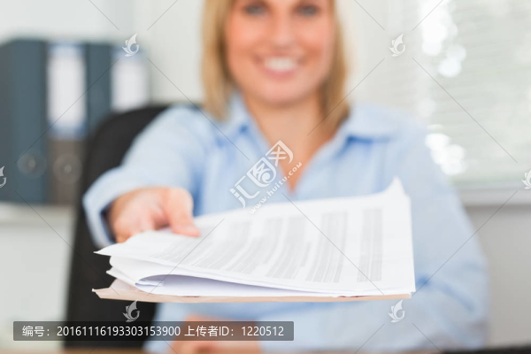 微笑的金發(fā)女商人通過展望相機(jī)