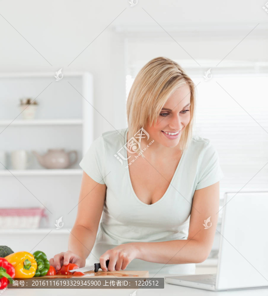 一位年輕女性在筆記本電腦上尋找食譜