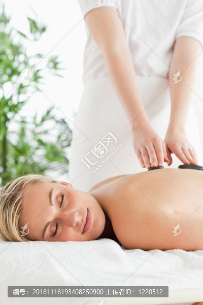 金發(fā)女人放松在按摩椅在石療法