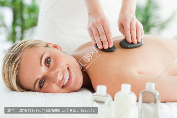 金發(fā)女郎微笑著接受石頭療法