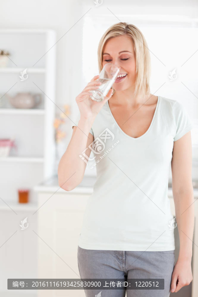 微笑的女人站著喝水