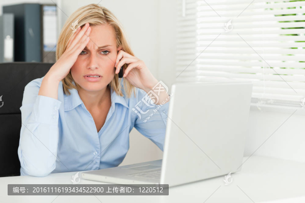 失意的商人坐在她的筆記本前打電話