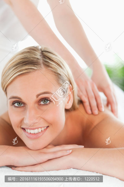 靠近一個(gè)微笑的女人放松在躺椅在健康中心按摩時(shí)