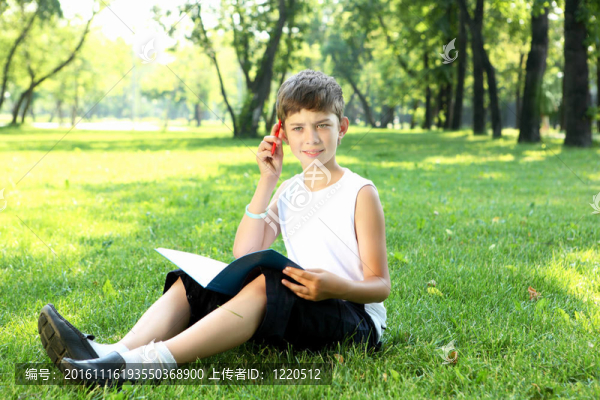 一個(gè)男孩在公園里拿著一本書的肖像