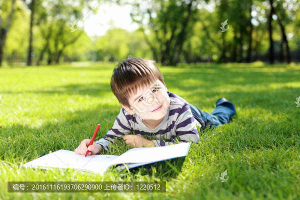 一個(gè)男孩在公園里拿著一本書的肖像