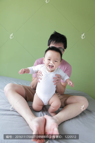 年輕的父親快樂的玩他的寶貝