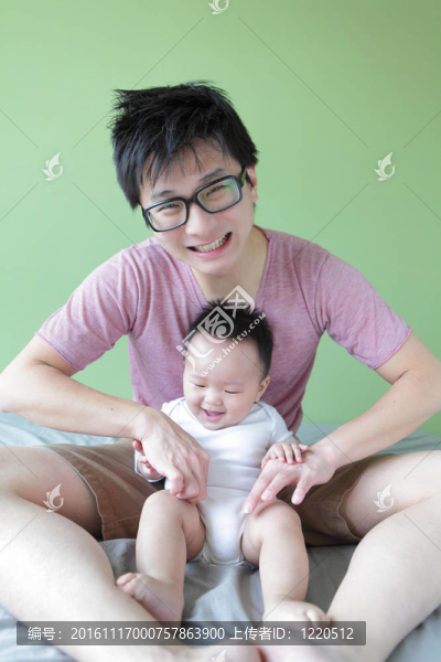 年輕的父親快樂的玩他的寶貝