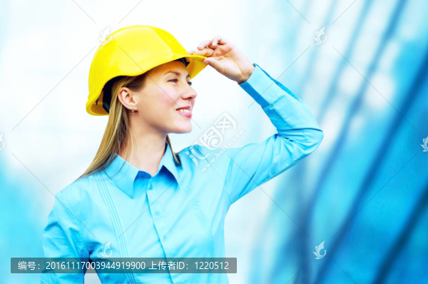 站在建筑物背景上的年輕建筑師女士戴著防護(hù)頭盔