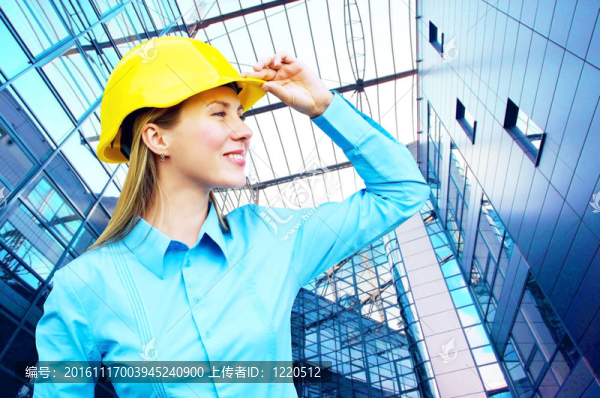 站在建筑物背景上的年輕建筑師女士戴著防護(hù)頭盔