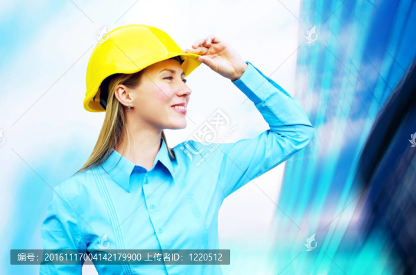 站在建筑物背景上的年輕建筑師女士戴著防護頭盔