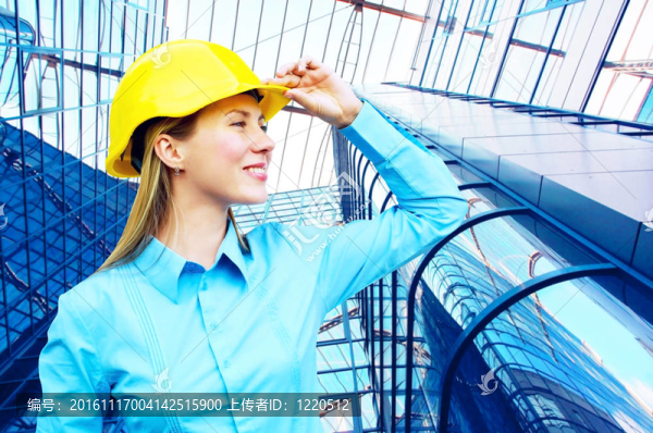 站在建筑物背景上的年輕建筑師女士戴著防護(hù)頭盔
