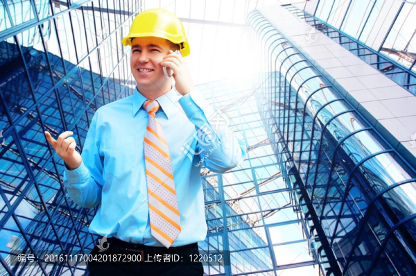 站在建筑物背景上的年輕建筑師戴著防護(hù)頭盔