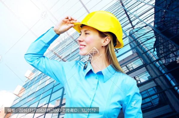站在建筑物背景上的年輕建筑師女士戴著防護(hù)頭盔