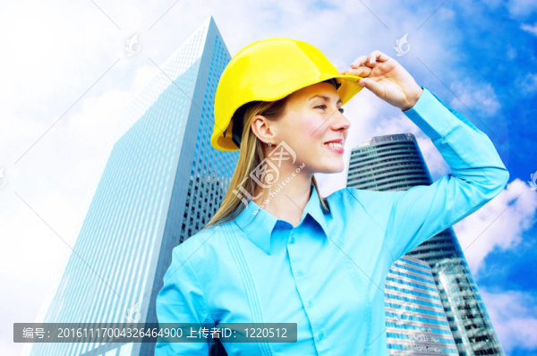 站在建筑物背景上的年輕建筑師女士戴著防護(hù)頭盔