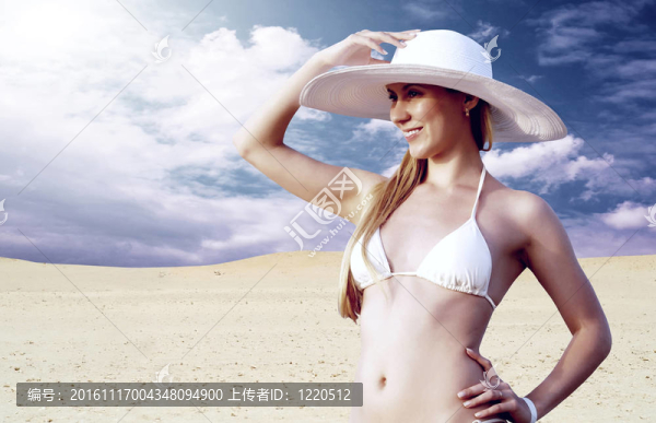 在whitebikini和帽子的年輕漂亮的女人；在陽光明媚的沙漠松弛