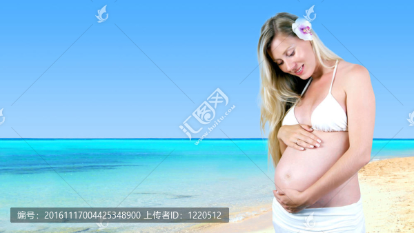 幸福的孕婦在陽光明媚的熱帶沙灘上