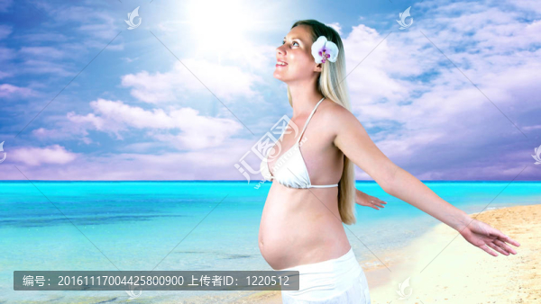 幸福的孕婦在陽光明媚的熱帶沙灘上