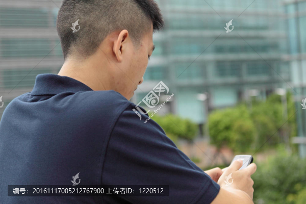 亞洲男子在手機(jī)上輸入信息。