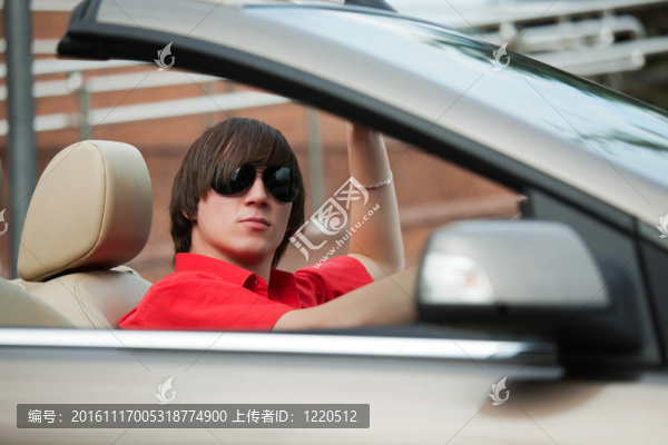 駕駛一輛敞篷車的年輕人