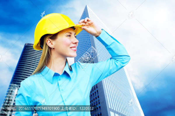站在建筑物背景上的年輕建筑師女士戴著防護(hù)頭盔