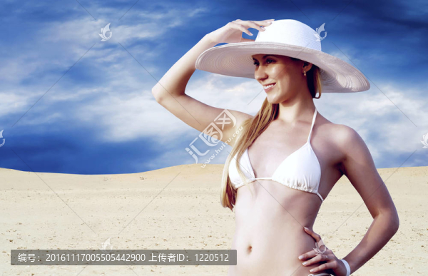 在whitebikini和帽子的年輕漂亮的女人；在陽光明媚的沙漠松弛