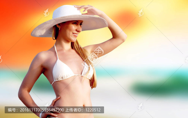 在比基尼和白帽子在陽光明媚的熱帶海灘的年輕漂亮的女人
