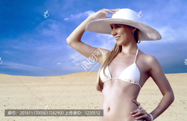 在whitebikini和帽子的年輕漂亮的女人；在陽光明媚的沙漠松弛