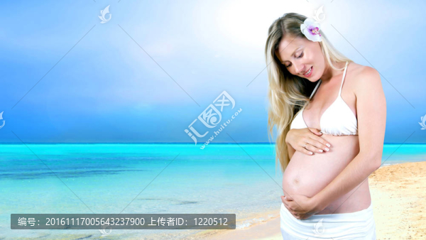 幸福的孕婦在陽(yáng)光明媚的熱帶沙灘上