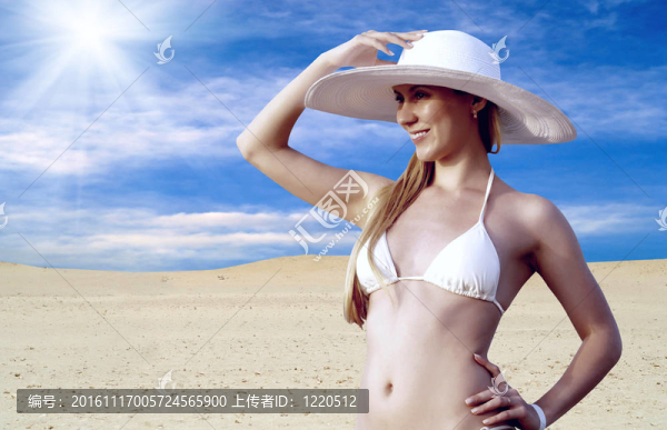 在whitebikini和帽子的年輕漂亮的女人；在陽(yáng)光明媚的沙漠松弛
