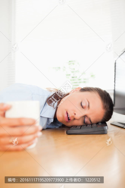 睡在辦公室的女商人拿著咖啡