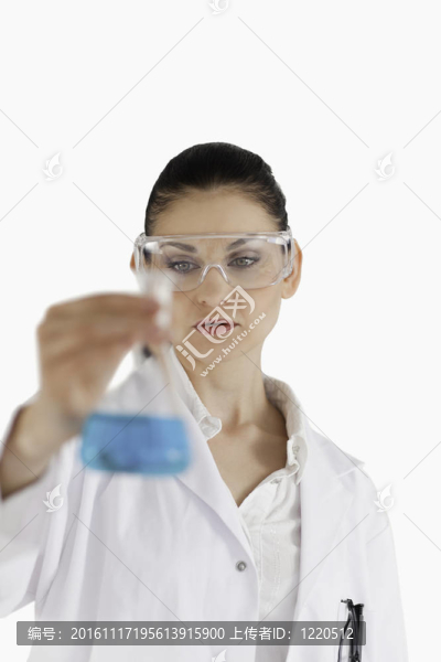 女科學(xué)家戴著安全眼鏡，在攝像機前拿著一個藍瓶