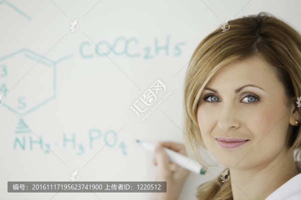 金發(fā)科學家看著相機，在實驗室的白板上寫公式