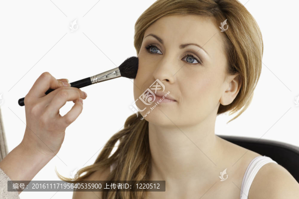 化妝師化妝申請(qǐng)一個(gè)可愛(ài)的金發(fā)女人