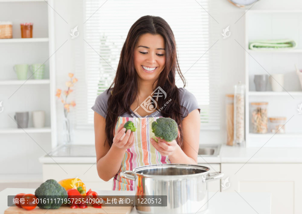 可愛的女人站著準備蔬菜