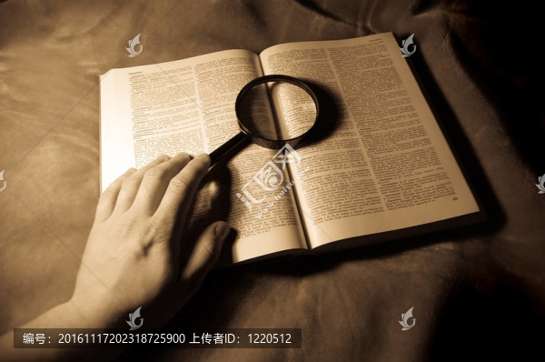放大鏡；書和人的手。