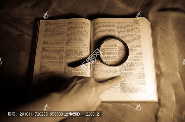 放大鏡；書和人的手。
