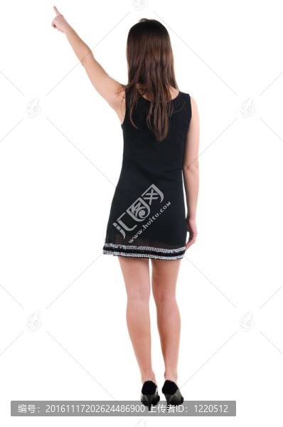 美麗的年輕女子在衣服指著墻壁。后視圖。