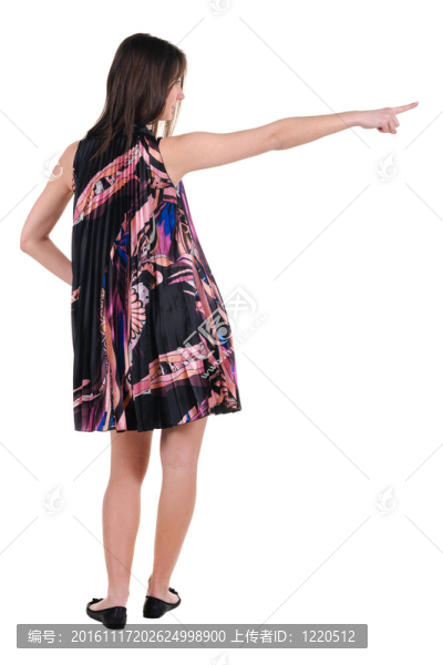 美麗的年輕女子在衣服指著墻壁。后視圖。