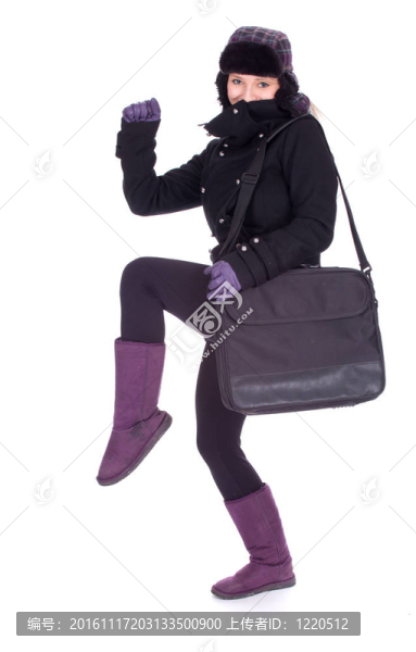美麗的年輕女子在冬季夾克和帽子與筆記本電腦包