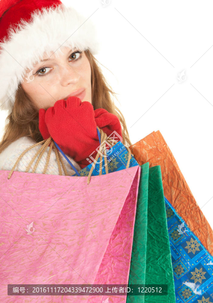 穿著Santa帽子的女孩帶著圣誕禮物帶著購(gòu)物袋；白色背景